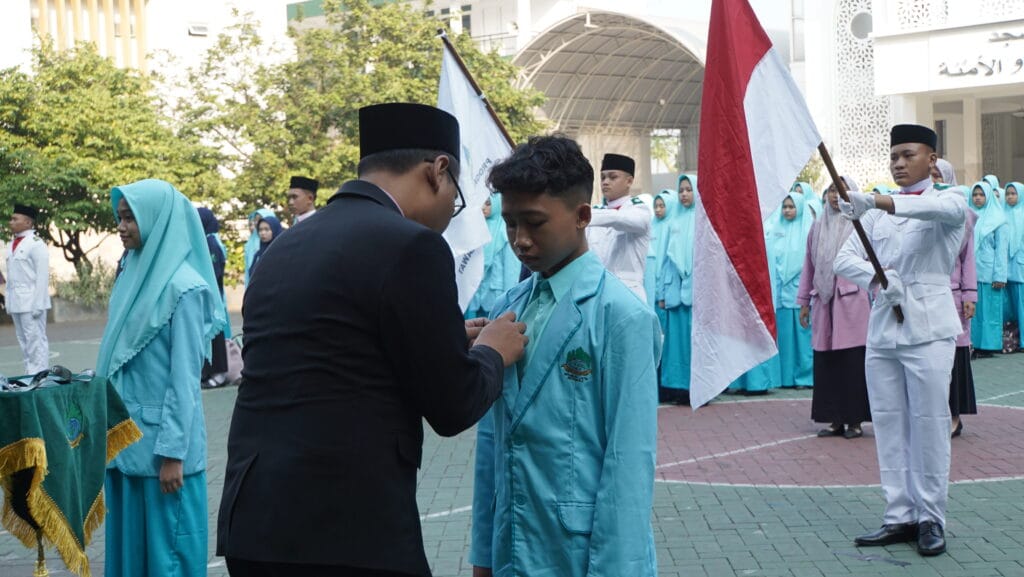 Gambar bapak Kepala Sekolah sedang penyematan simbolis tanda peserta MPLS SMA Progresif Bumi Shalawat