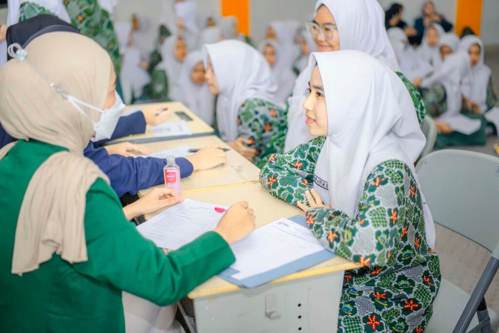 Siswa SMA Progresif Bumi Shalawat sedang melakukan pemeriksaan dengan mahasiswa ISMKI